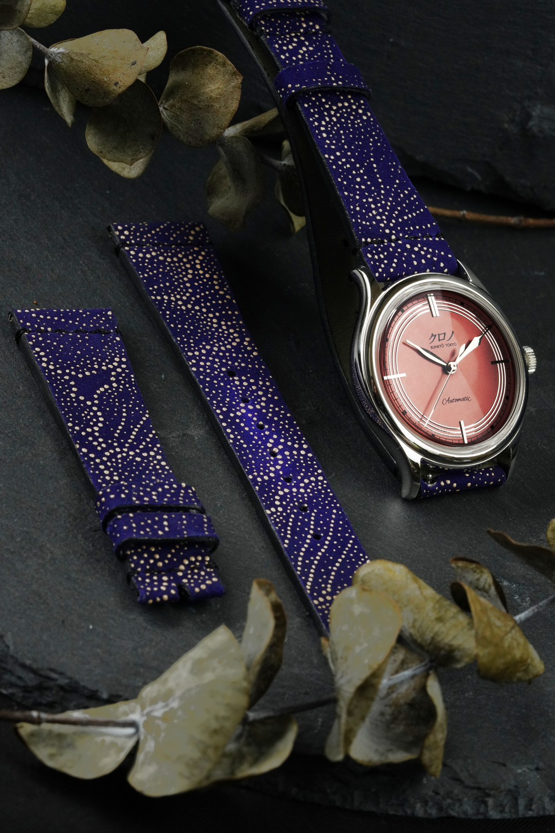 blue strap with pink dial on rock plate and leaf background