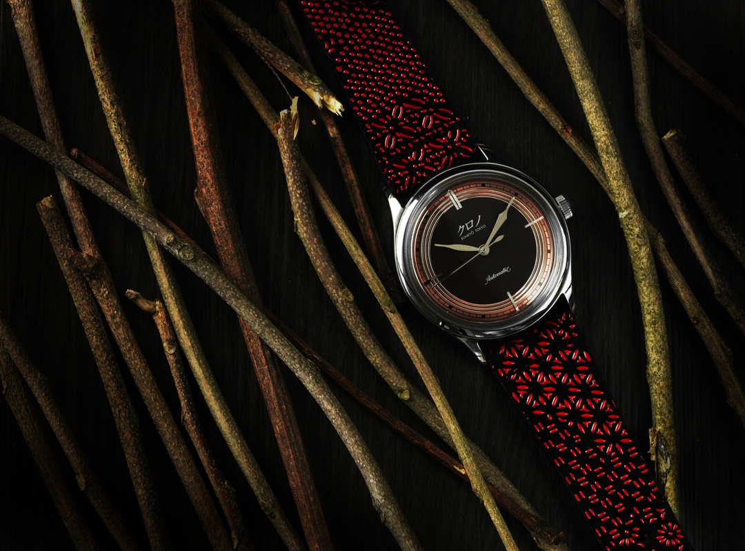 red and black watch strap with black and gold dial